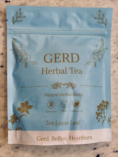 A 3 oz pouch of Gerd Herbal Tea on a speckled beige countertop. The packaging is light blue with gold foil botanical illustrations and text reading 'GERD Herbal Tea' and 'Gerd.
